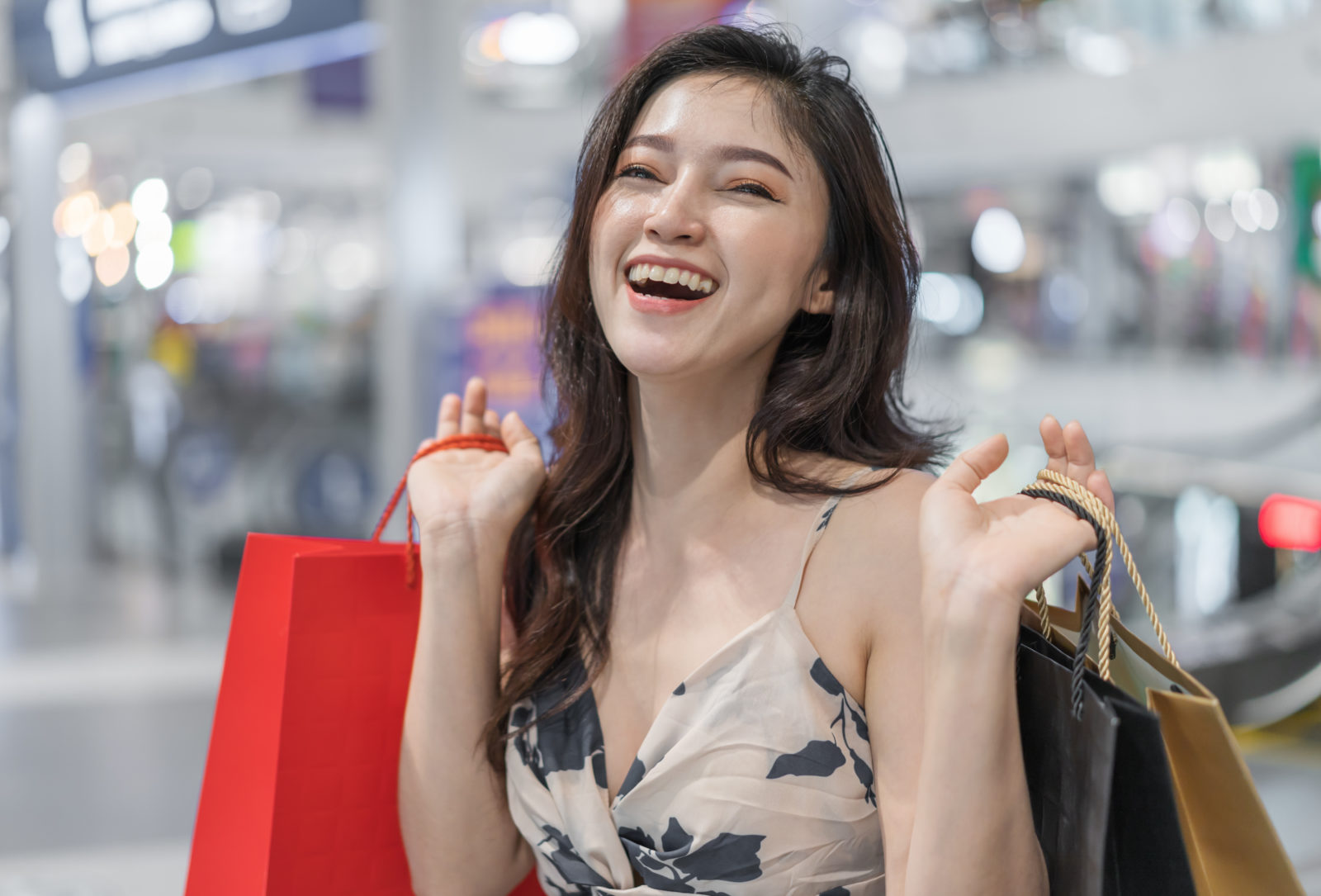 cheerful woman with shopping bags in mall